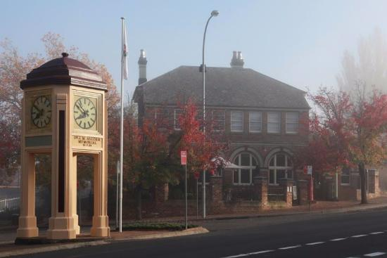 Memorial clock tower and historic building in morning fog